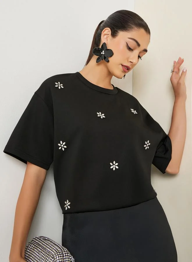 تيشيرت أسود واسع مزين بتفاصيل براقة