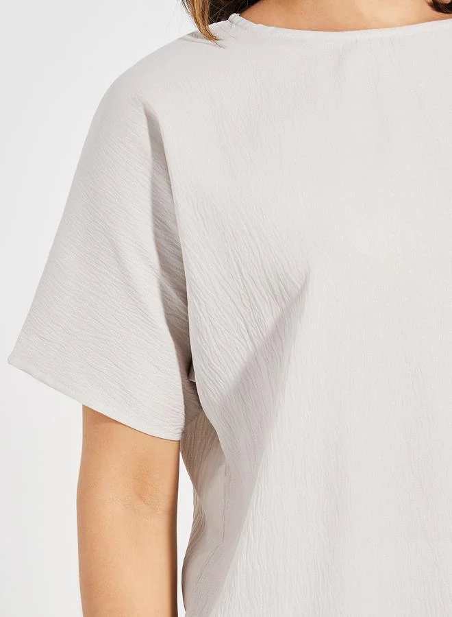 طقم بلوزة بياقة مستديرة بنقشة بارزة وبنطلون واسع الأرجل